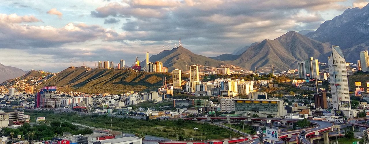 View of Monterrey with the city in the foreground and mountains in the background.