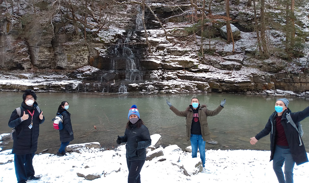 Five students on a snowy winter hike in a gorge with a stream