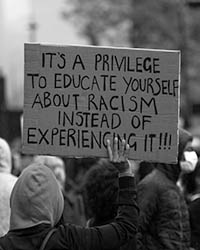 Sign that reads It's a Privilege to Educate Yourself About Racism Instead of Experiencing It