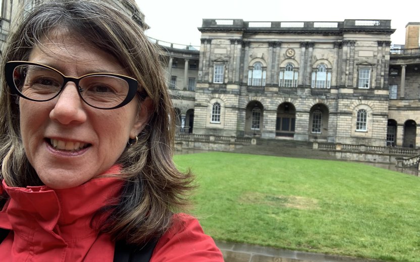 Wendy taking a selfie in front of University of Edinburgh.