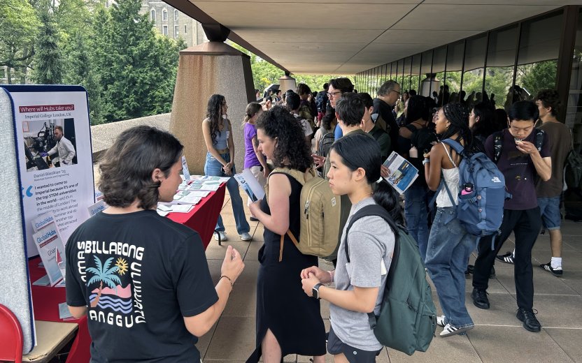 Students walking through the fair under Uris Terrace.