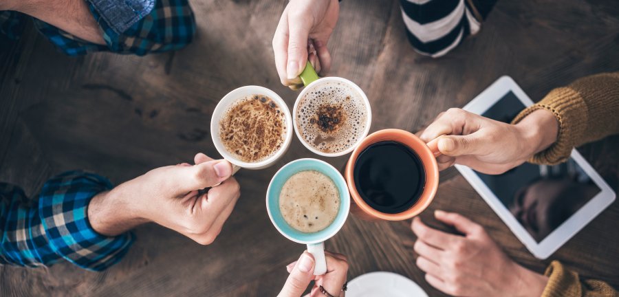 Looking into four cups of coffee from above.