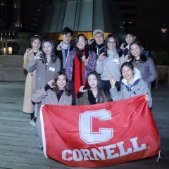 A group of students holding a Cornell banner.