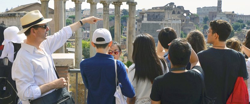 Guide showing students ruins in Rome.