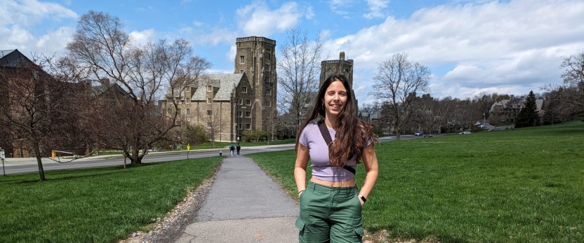 Mariana walks across the Cornell Ithaca campus with her hands in her pockets.