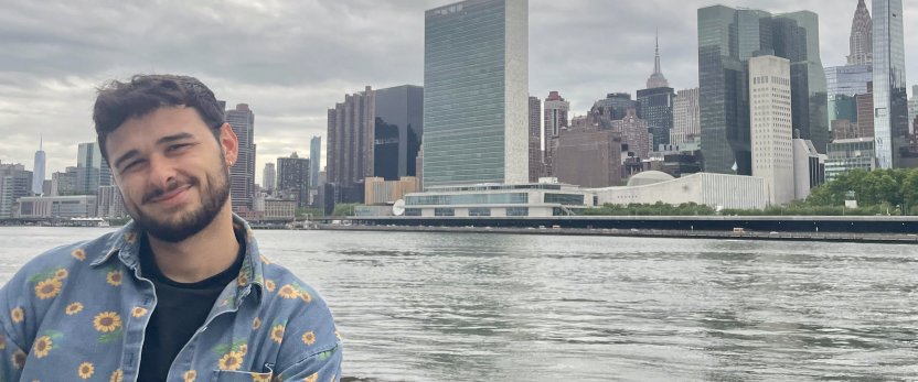 Pierre-Raphael poses for a photo in front of a New York city skyline.