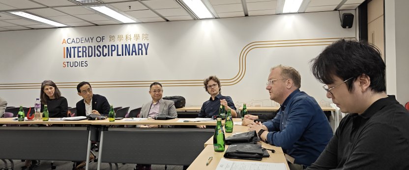 People in discussion, sitting at an L-shaped table.