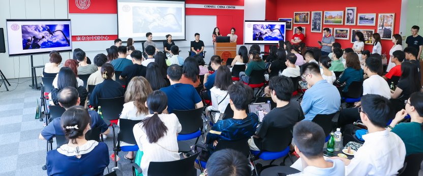 A full-house of people seated during a presentation.