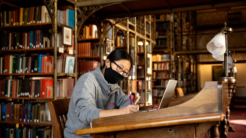 Student sitting at a desk in the AD White Library.