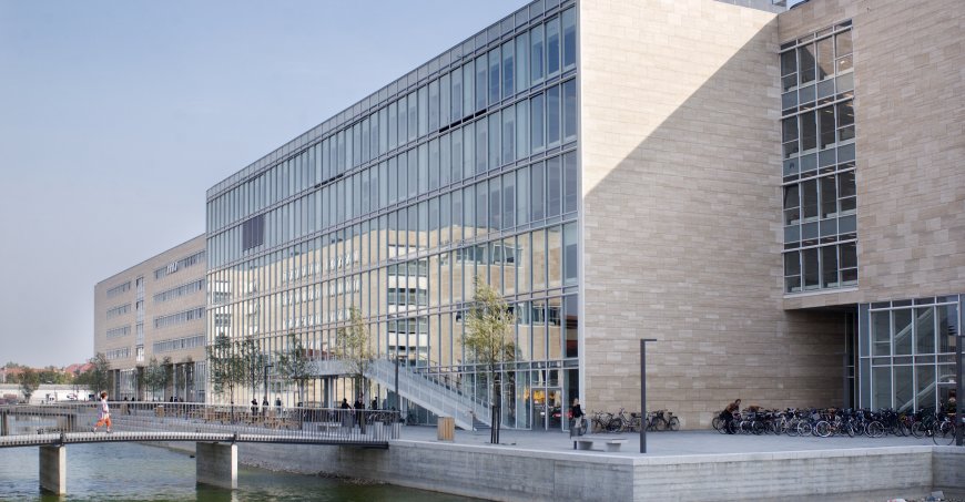A footbridge over a waterway connected to a modern building