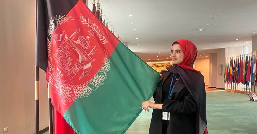 Mursal Rahim is touching an Afghan flag displayed at the UN.