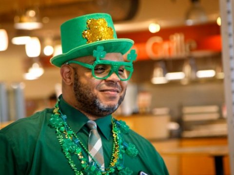 Man dressed in green clothing, hat, glasses with shamrocks