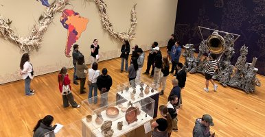 Guests at the Johnson Museum gather around a tour guide and the art of the "Armonía de la Esfera" exhibition. 