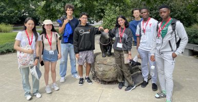 Students standing around the bronze statue of Touchdown.