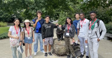 Students standing around the bronze statue of Touchdown.