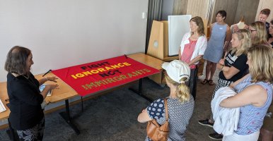 Teachers view a fabric sign that reads, "Fight Ignorance Not Immirgrance."