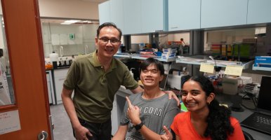Frank Fang in the center with his PI and another student in the lab. 