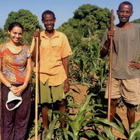 Shanti Kumar ’17 stands with two farmers in a field in Toliara, Madagascar