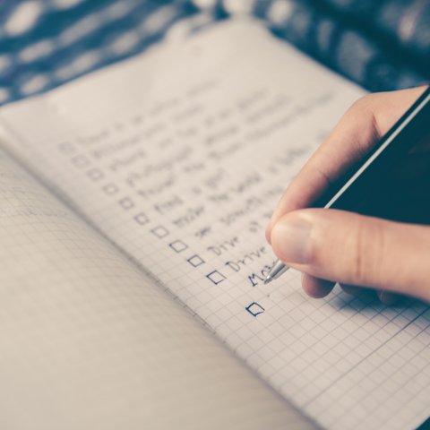 Hand writing checklist on page in journal