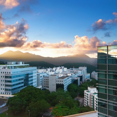 Skyline view of HKUST campus with glass building in the foreground.